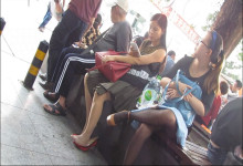 Middle-aged Woman is Using Her Phone and Play Her Shoe